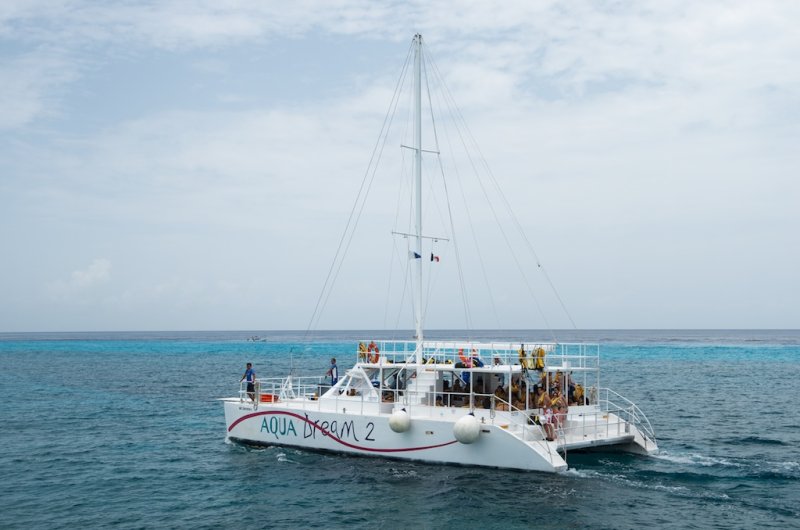 Aqua Dream 2 catamaran under sail on the turquoise Caribbean water near the Cozumel reef line