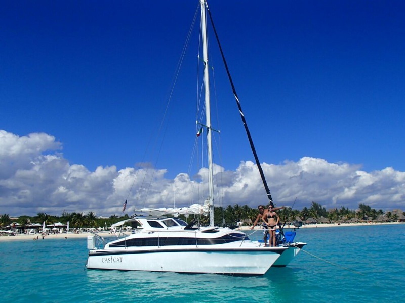 catamaran charter for Belize sailing vacation, anchored near Caribbean reef at Caye Caulker