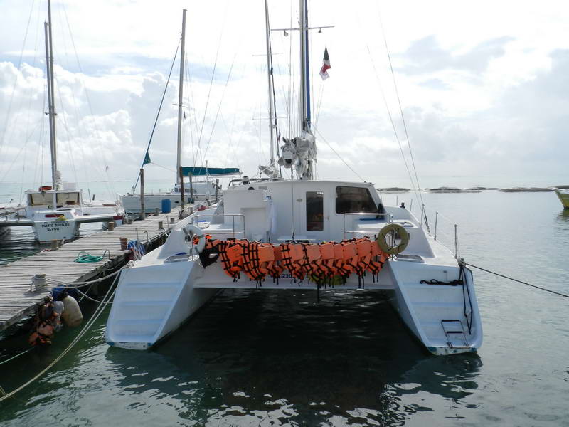 Catamaran JOLO anchored in calm turquoise water at Marina Maroma on the Riviera Maya, private sailing charter rental
