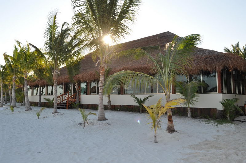 Mesa elegantemente montada sobre la arena blanca del restaurante de Playa Maroma, Riviera Maya, lista para una celebración privada