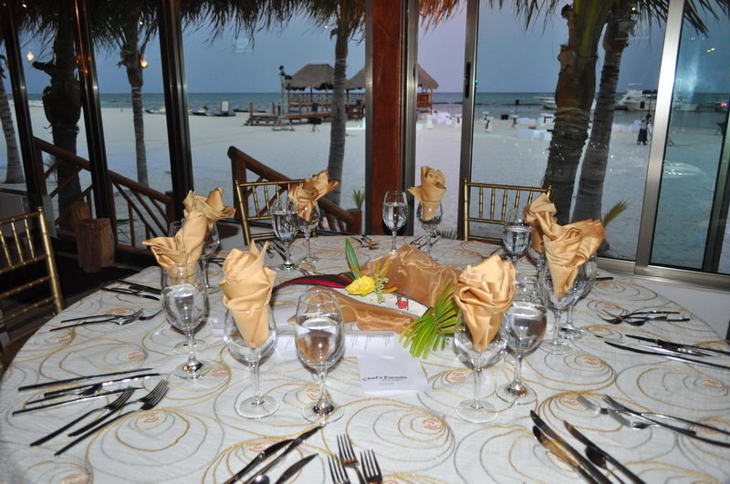 Mesa romántica iluminada con velas para dos en Playa Maroma, Riviera Maya