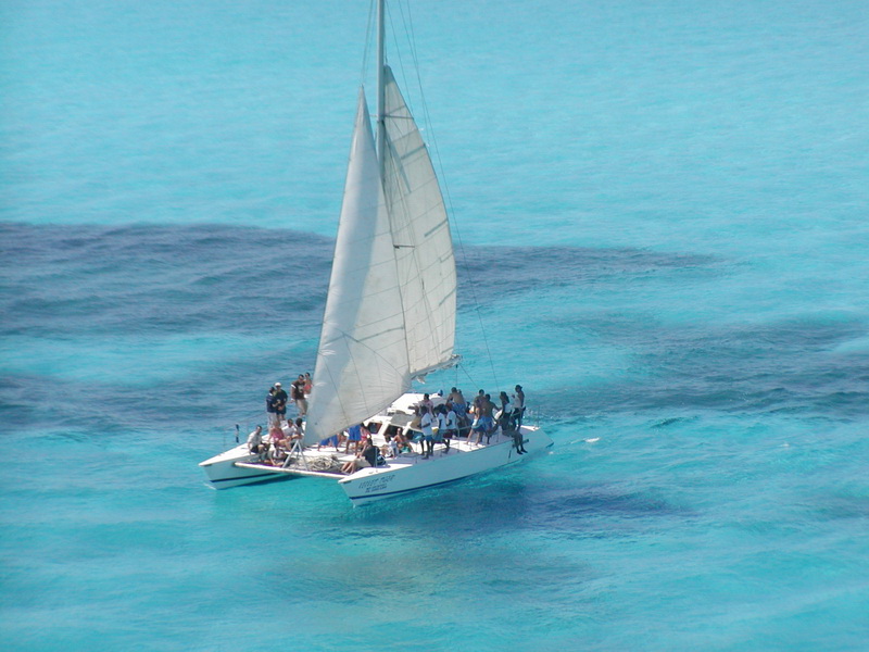Guests enjoying the spacious deck of the Tiger catamaran on a private sailing tour from Cancun to Isla Mujeres
