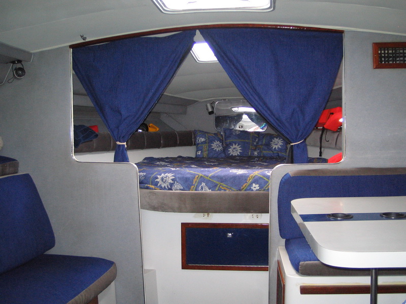 Interior de la cabina del Wellcraft 33 con tapicería azul, camarote, comedor y baño para descansar entre jornadas de pesca en Cancún